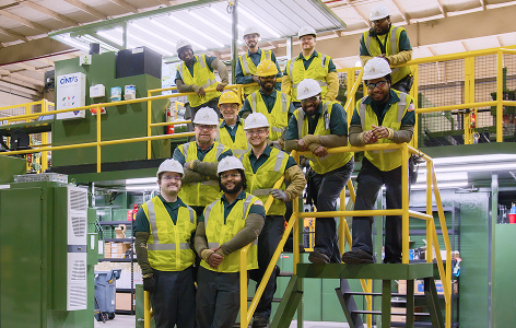 Smiling group of Reliance factory workers with protective gear