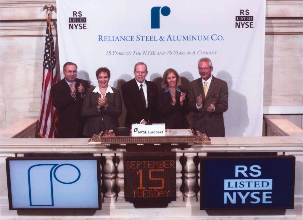 Three-member Reliance leadership team portrait in an office setting.