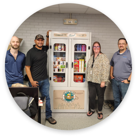 Four people beside a community food pantry.