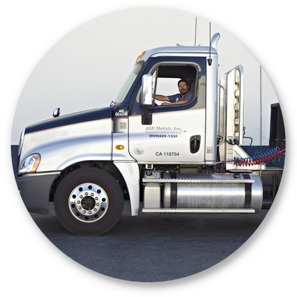 AMI Metals truck driver seated in a delivery truck outside a warehouse facility.